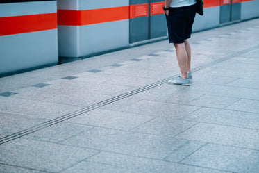 persons legs standing on a grey tiled floor