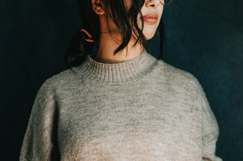persons torso and neck in a grey sweater
