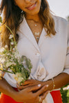 persons torso in white dress holding bunch of white flowers