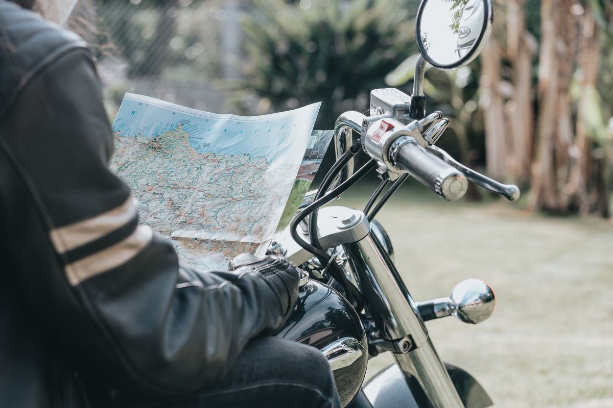 一个人骑着摩托车，手里拿着一张地图