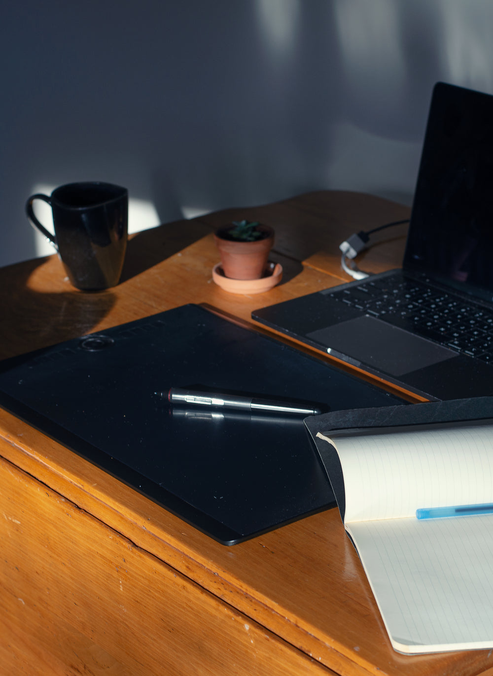 photo of a desk with a pen laying on a tablet