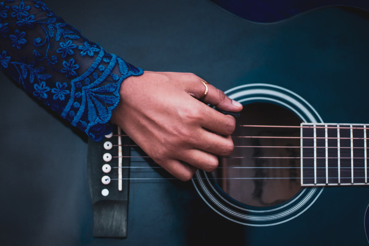 photo of a hand about to play the guitar