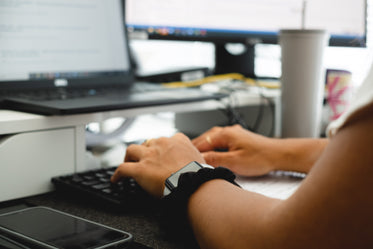 photo of a person typing with both hands on keyboard