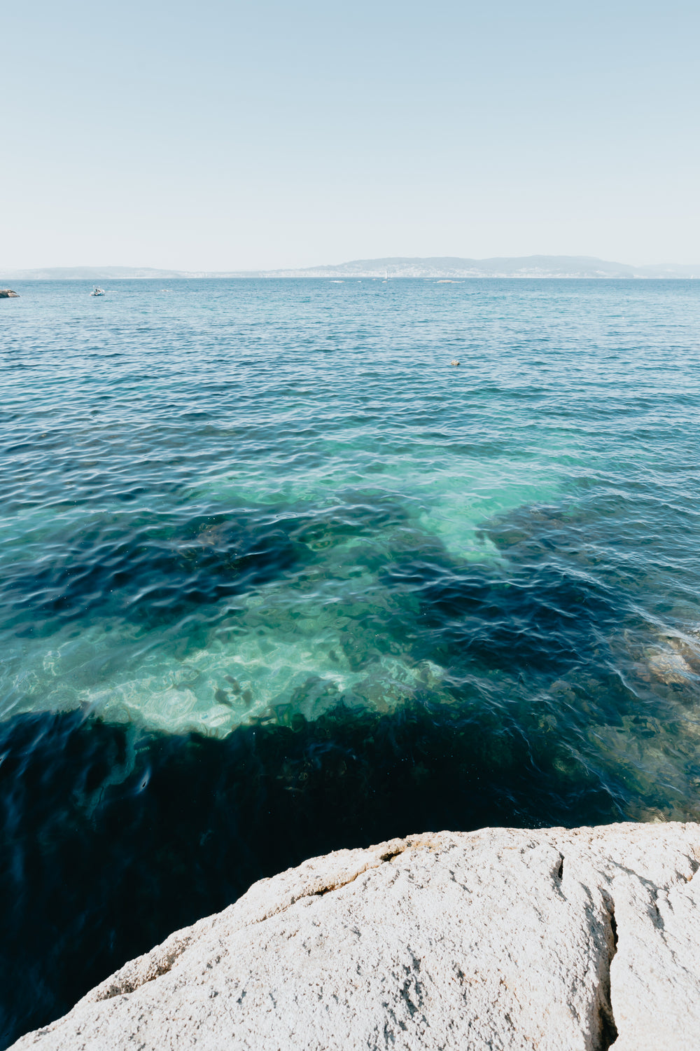 photo of blue water and distant land