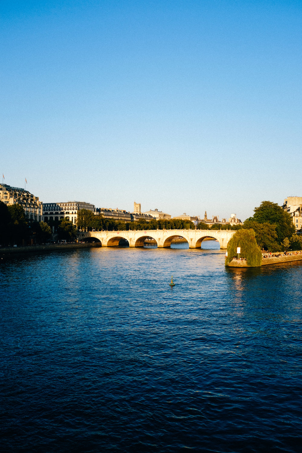 photo of blue water with a bridge and a city