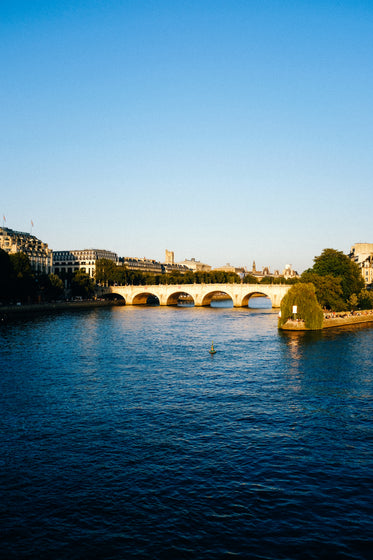 photo of blue water with a bridge and a city