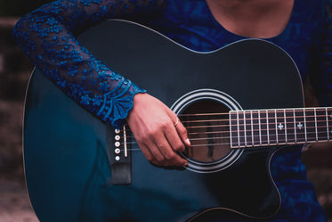 photo of the mouth of a blue guitar with an arm on it