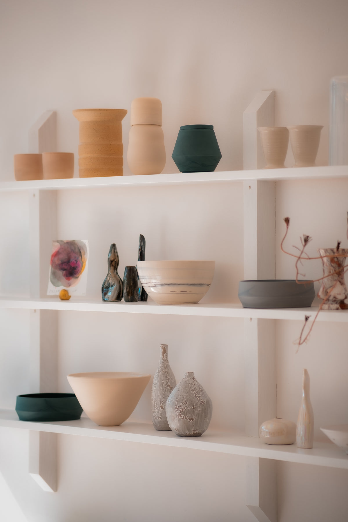 photo of white shelves filled with pottery