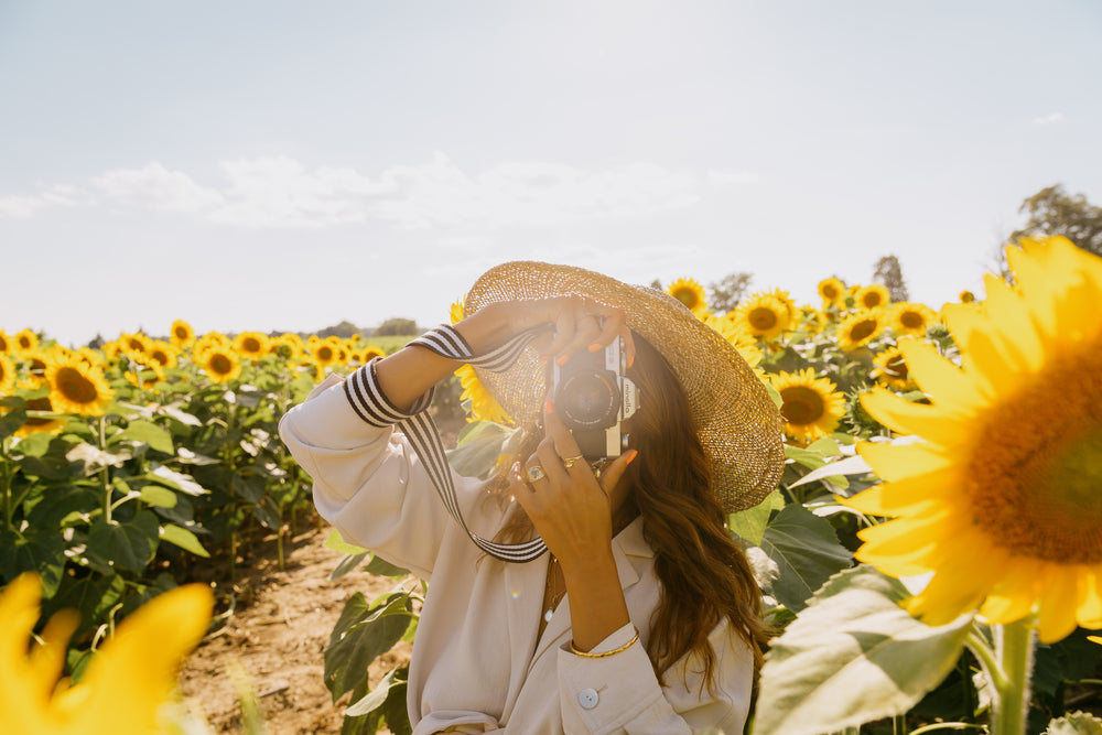 photograher standing in sunflower field