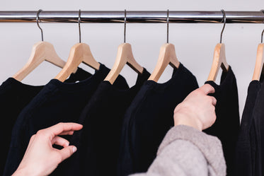 picking a dark shirt from a clothes rack