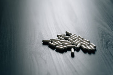 pile of white pills on a dark grey surface