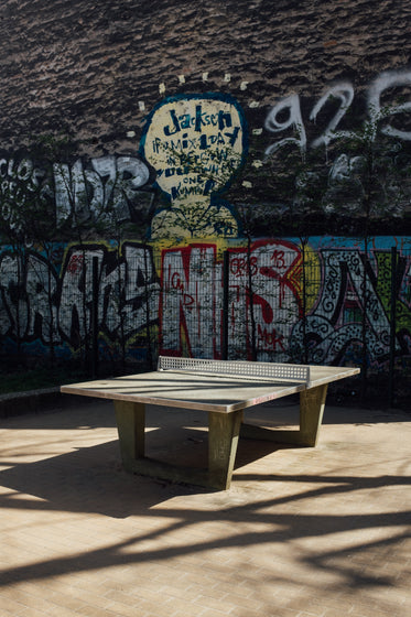 ping pong table in front of graffiti wall