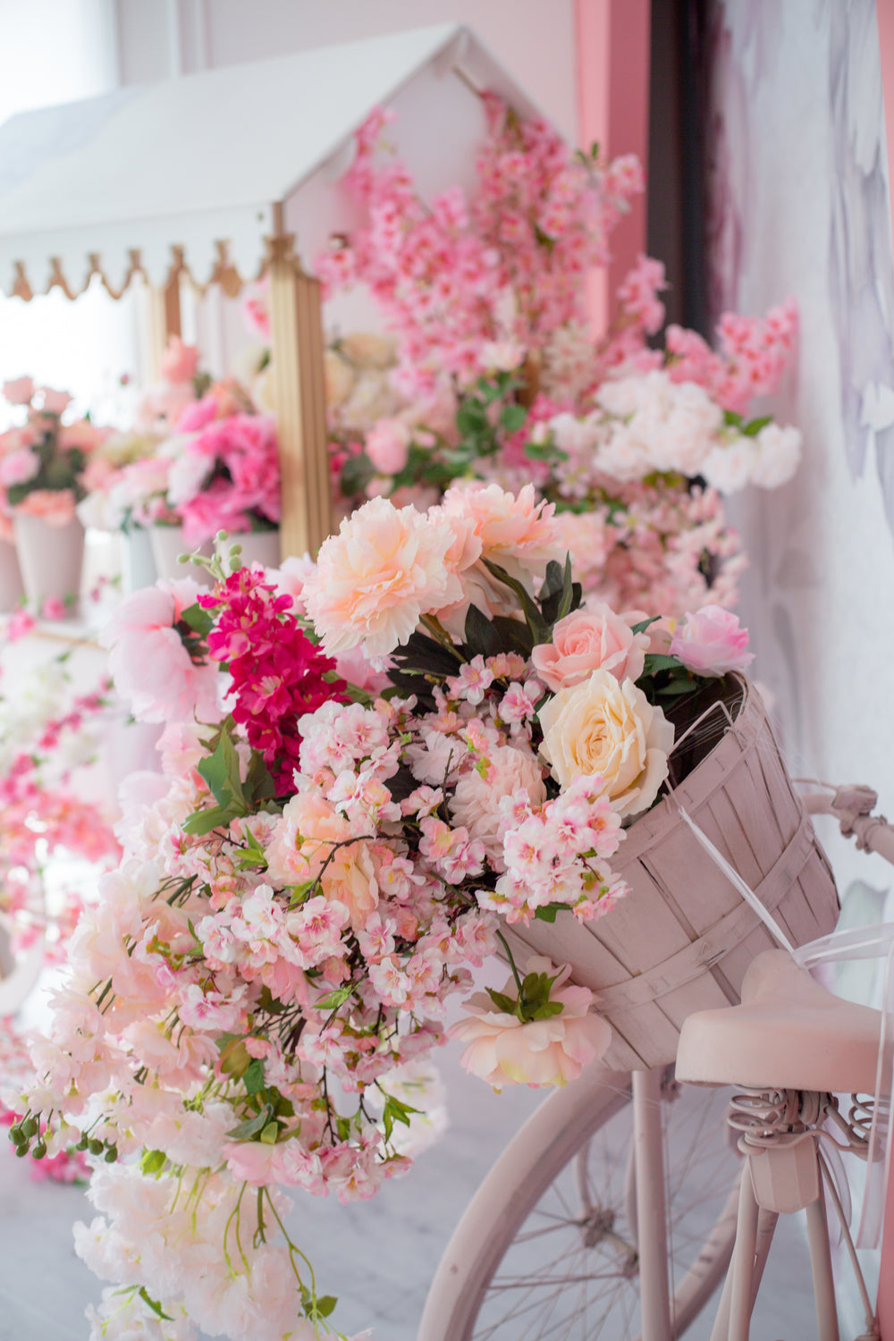 pink bike with a basket full of flowers