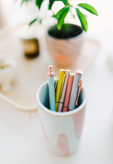 pink cup full of pens