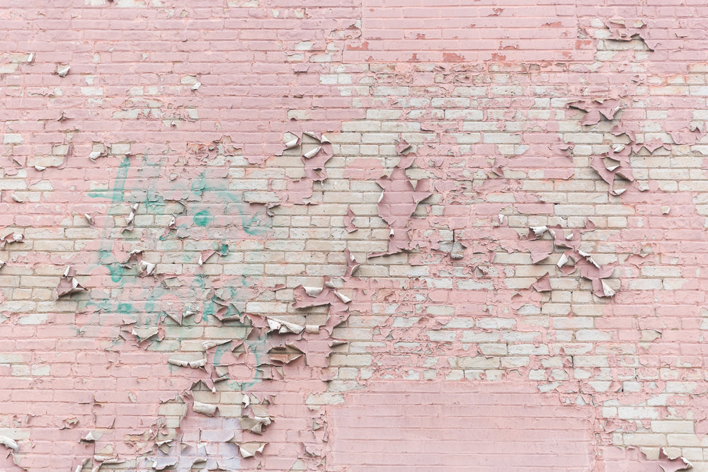 pink paint peeling off brick wall texture