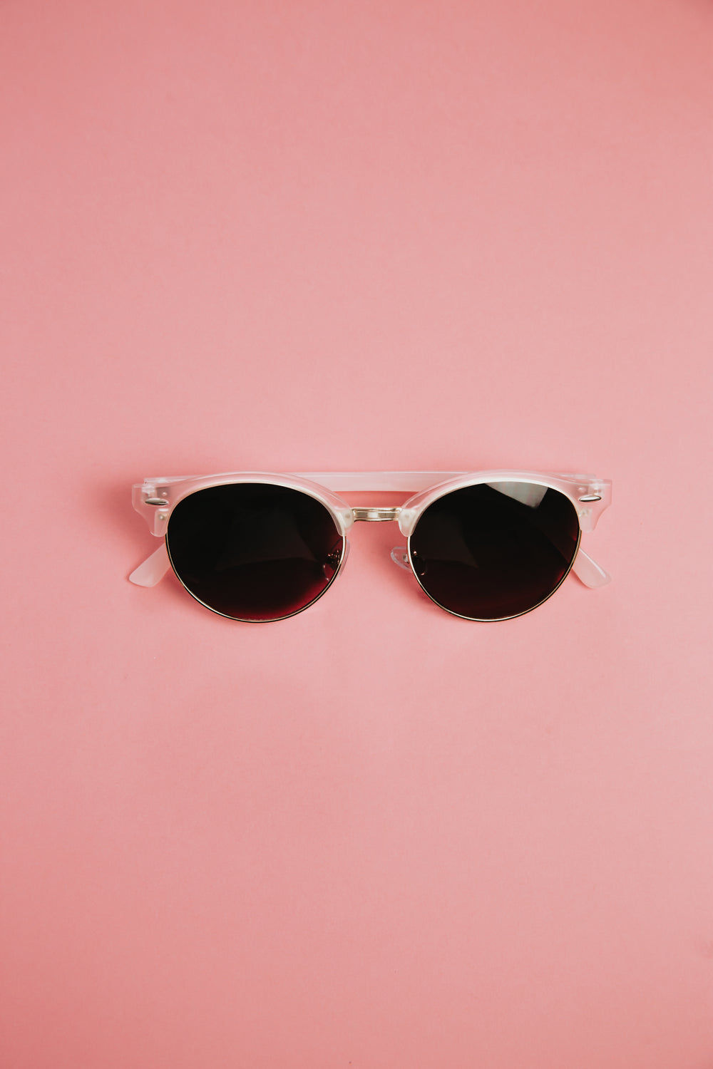 pink sunglasses sit in the middle of the frame