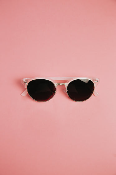 pink sunglasses sit in the middle of the frame