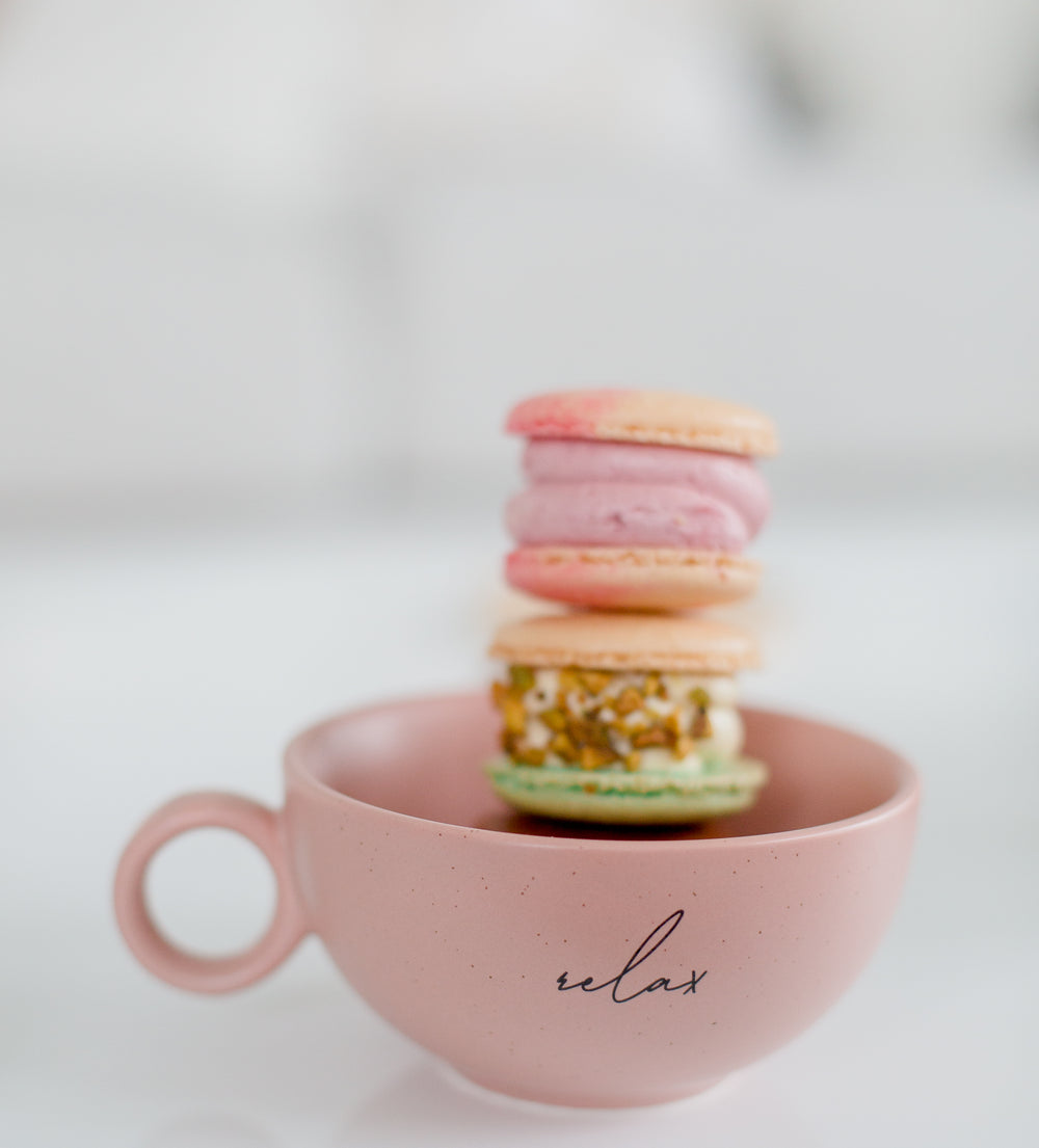 pink teacup filled with macarons