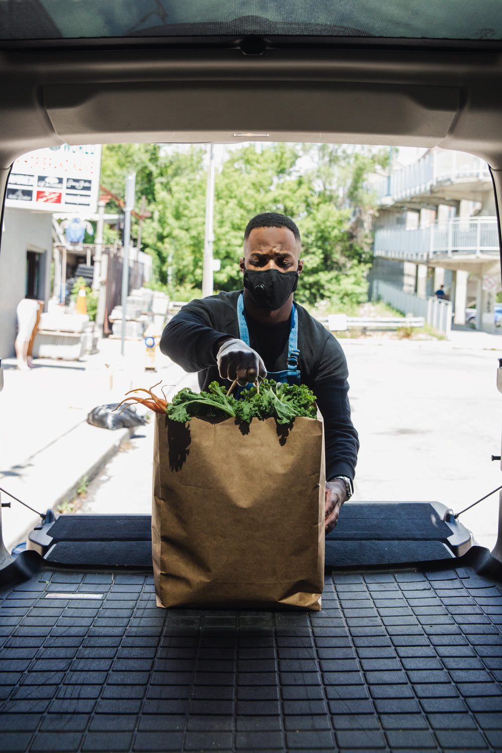 placing groceries in the trunk of a car