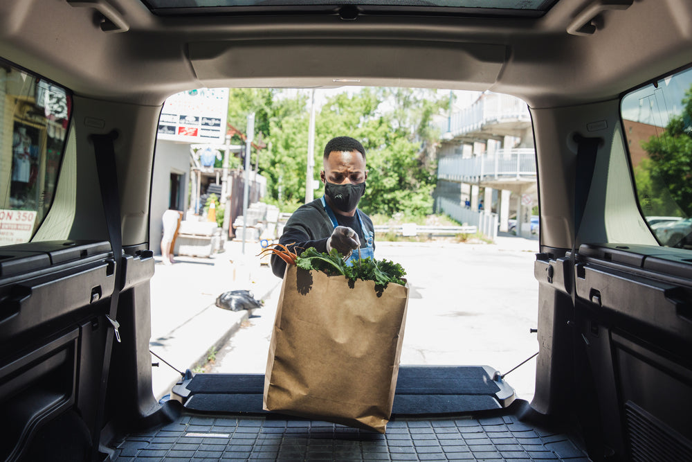 placing some groceries in trunk for curbside pickup