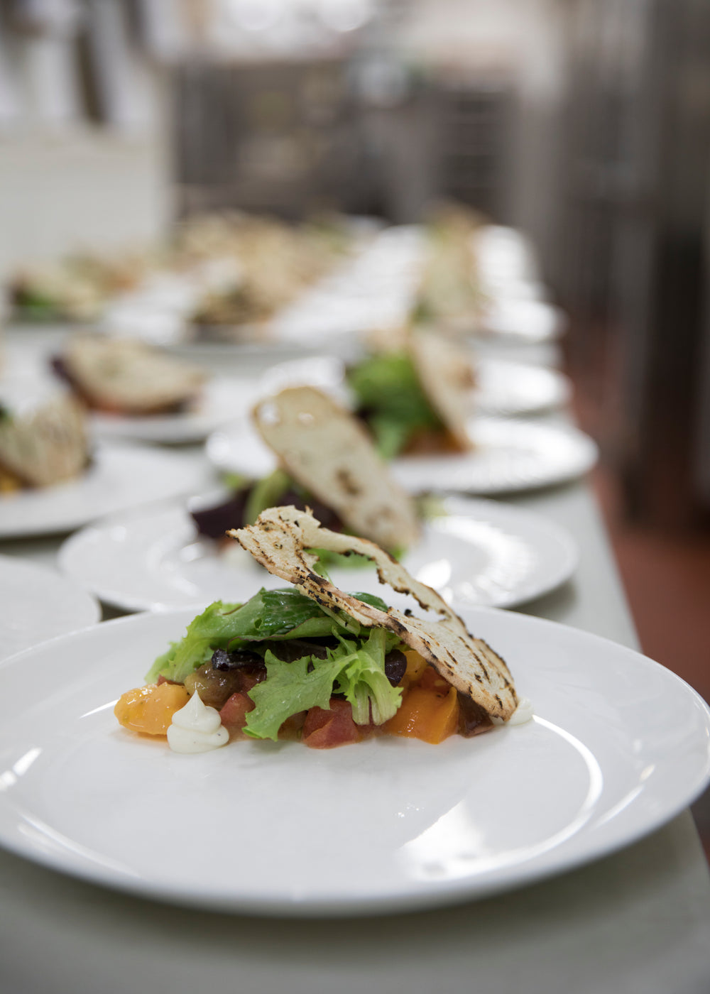 plates being prepared for service in a restaurant kitchen