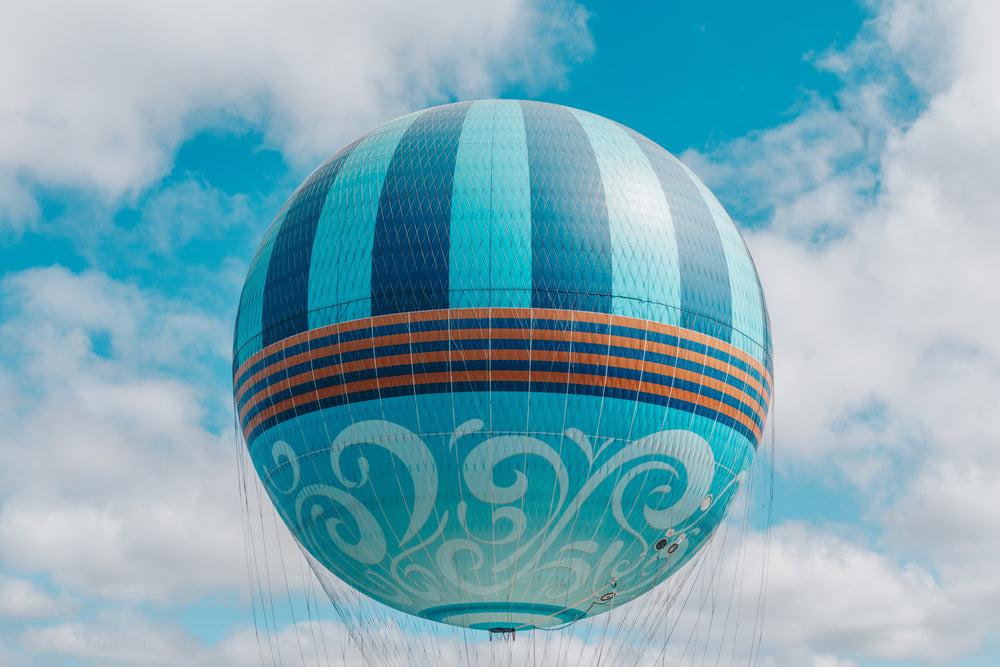 playful patterned sphere hot air balloon floats in blue sky