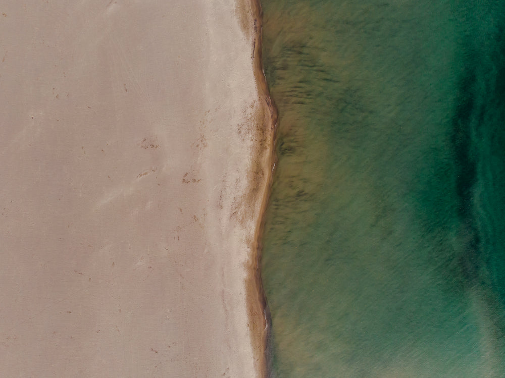 portrait image of contrast between sand and sea