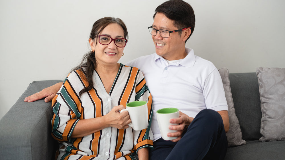 portrait of a couple sitting on a grey couch