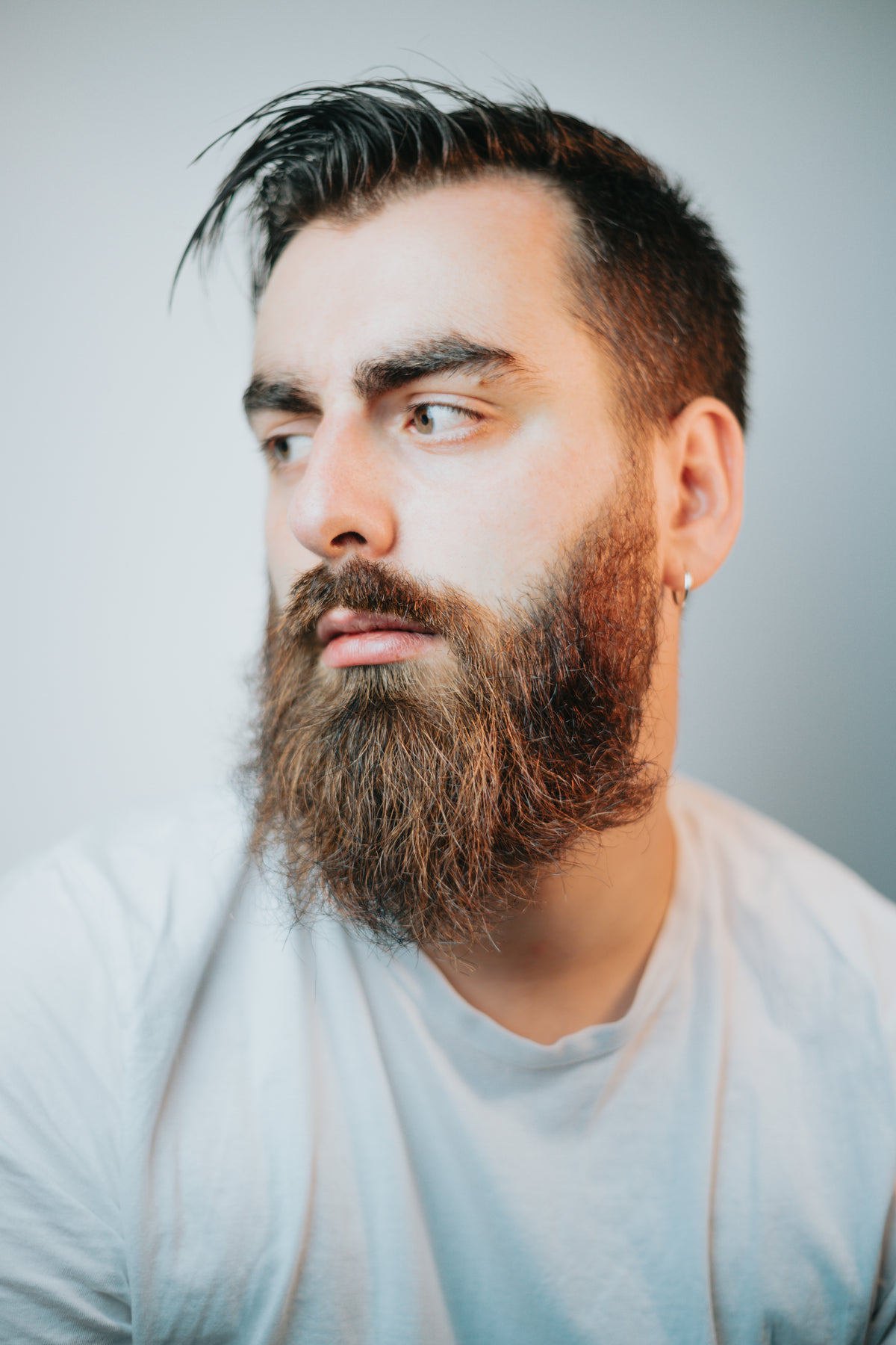 portrait of a man with a full beard looking left