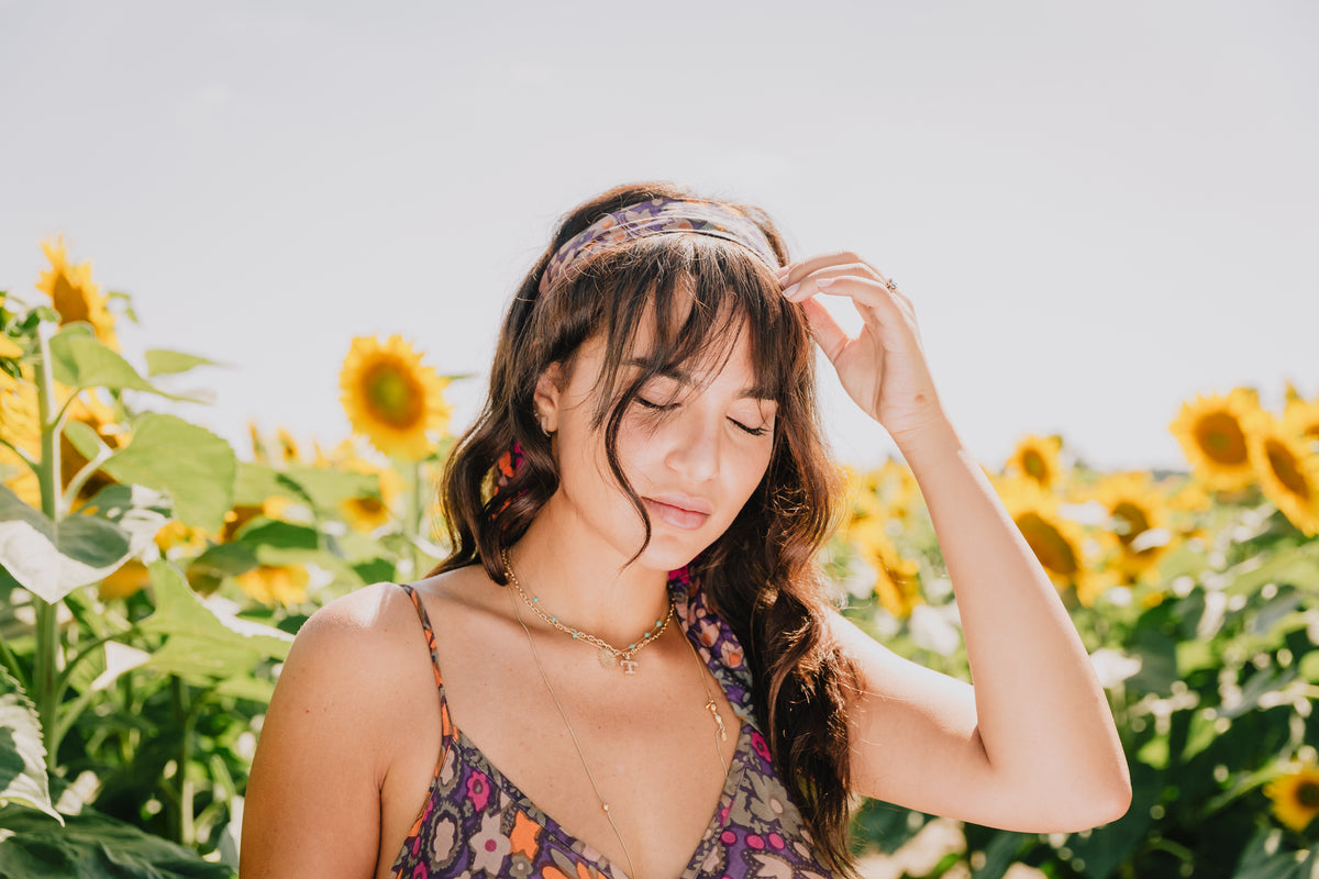 portrait of a woman with her eyes closed by a sunflower field