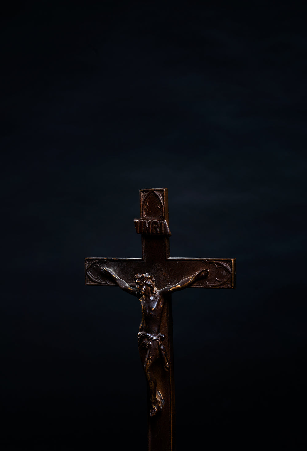 portrait of a wooden cross on black background