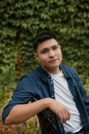 portrait of a young adult resting their arm on chair