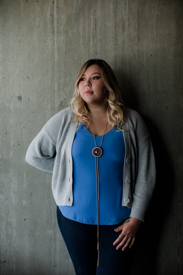 portrait of person leaning against a cement wall