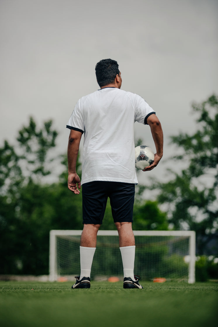 Portrait Of Soccer Player Holding Ball On Empty Field