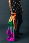portrait of tattoos bracelets and rings holding pride flag