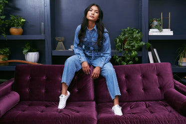 posing against dark blue feature wall