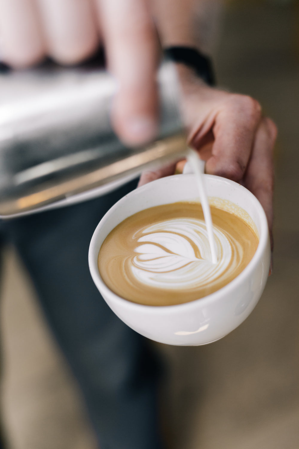 pouring steamed milk in espresso to make heart