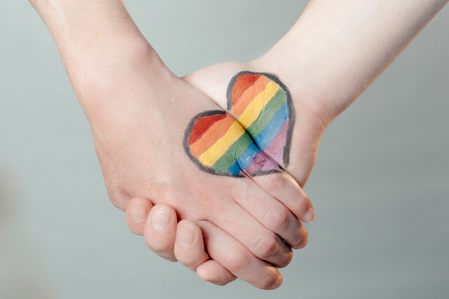 coração do orgulho gay nas mãos dadas