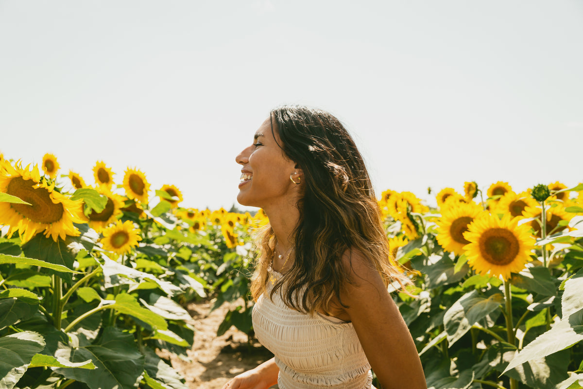profile of a person smiling in a sunflower field