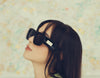 profile of a woman wearing bold black sunglasses