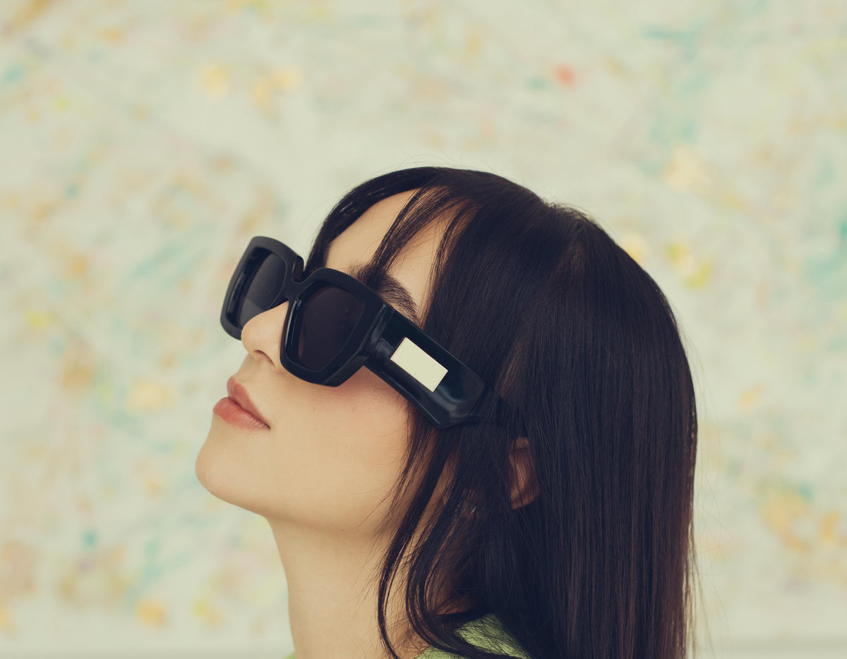 profile of a woman wearing bold black sunglasses