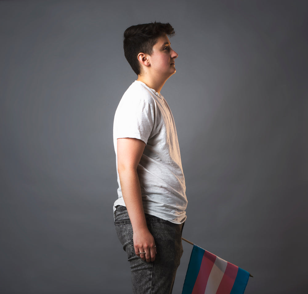 profile shot of person holding trans pride flag