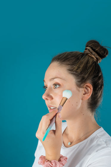 profile view of a woman doing her makeup