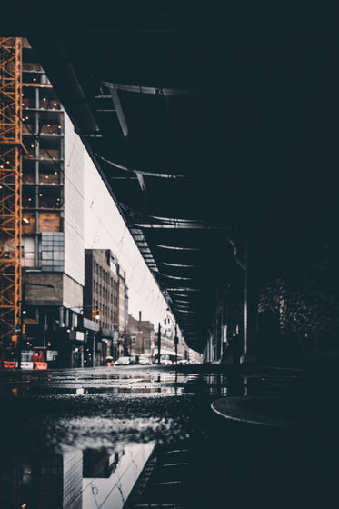 puddle water reflects urban bridge