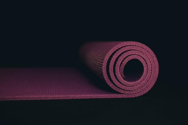 Purple Yoga Mat Partially Rolled On Black