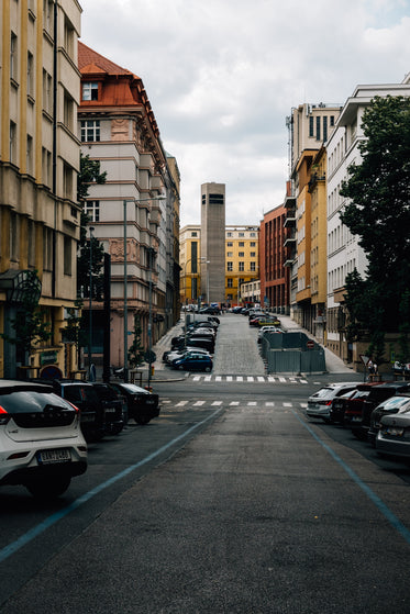 quiet city street lined with colorful buildings and parked cars