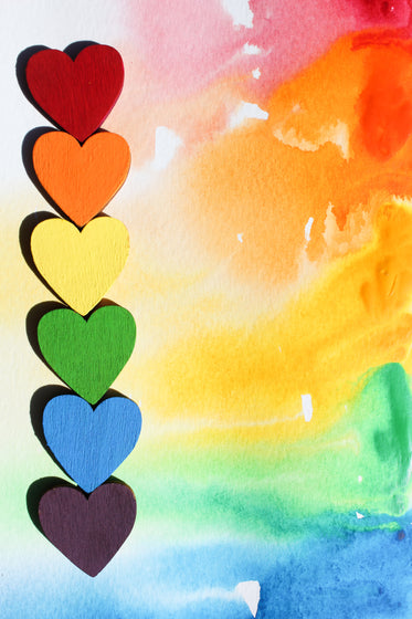 rainbow hearts lined up tip to tip along watercolour canvas