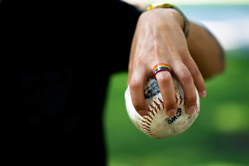 rainbow ring on hand holding softball