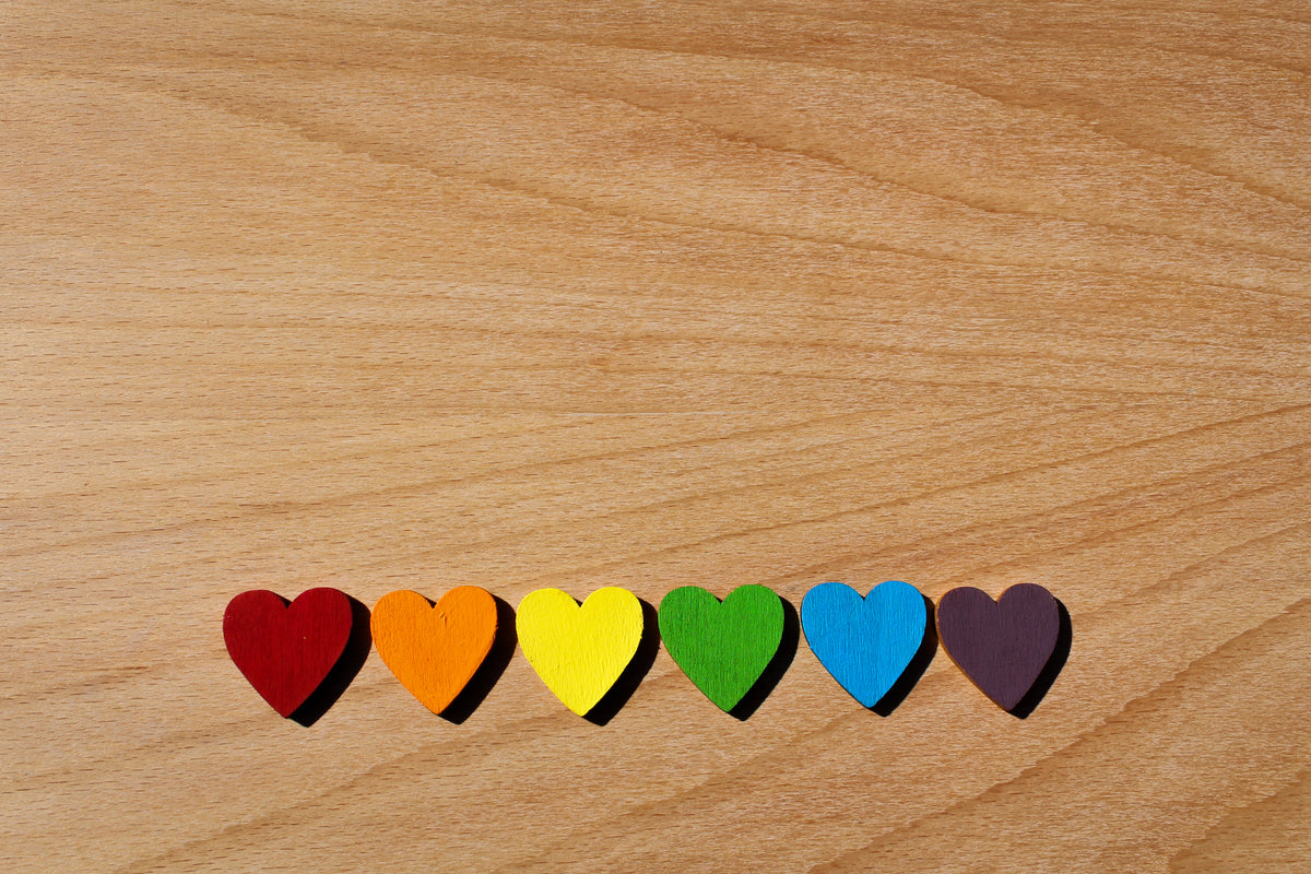 rainbow wooden hearts lined up on oak table