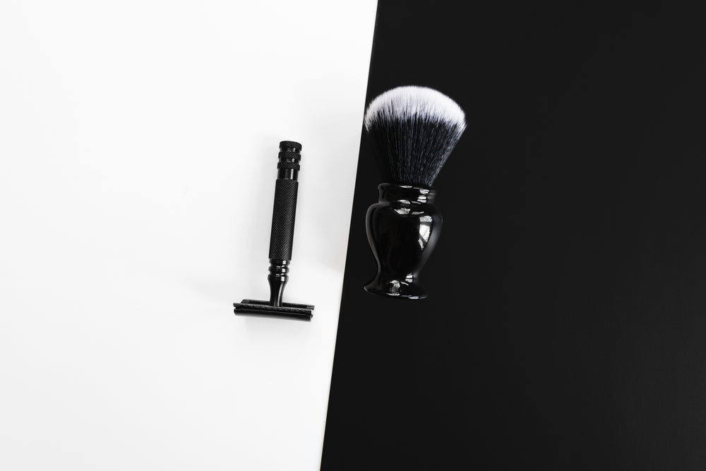 razor and shaving brush on black and white